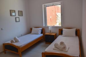 two twin beds in a room with a window at Aegean Aura Apartment III in Kalymnos