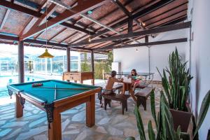 two people sitting in a patio with a pool table at Pousada das Videiras in Monte Verde