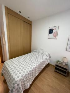 Schlafzimmer mit einem Bett und einer Holztür in der Unterkunft Apartamento en Ares in Ares
