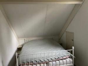 ein kleines Bett in einem kleinen Zimmer im Dachgeschoss in der Unterkunft Wielewaal in Ewijk