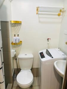 y baño con aseo blanco y lavamanos. en Spring Residences Affordable Staycation Bicutan Paranaque near NAIA Airport, en Manila
