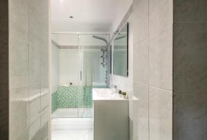 une salle de bain blanche avec un lavabo et une douche dans l'établissement Incantevole Appartamento Banchi di Sopra, à Sienne