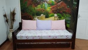 a bed in a room with a painting of a garden at Refúgio em Petrópolis in Petrópolis