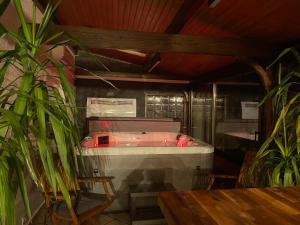 bañera en una habitación con mesa y plantas en Appt privé, Jaccuzi pro, 2 pers, 100m2, jardin, proche, Parc des Expositions, Aéroport CDG, Villepinte en Villepinte