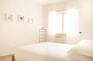 una camera bianca con un letto e una finestra di Appartamento Moderno e Luminoso (Metro B) a Roma