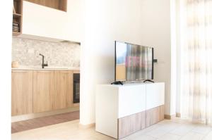 una televisione su un supporto bianco in una cucina di Appartamento Moderno e Luminoso (Metro B) a Roma