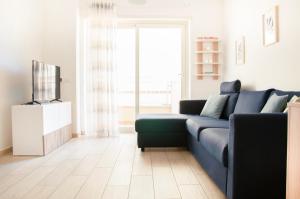salon z niebieską kanapą i telewizorem w obiekcie Appartamento Moderno e Luminoso (Metro B) w Rzymie