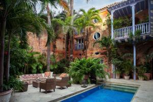 ein Haus mit einem Pool und Palmen in der Unterkunft Luxury 10 BR Colonial Mansion in Cartagena de Indias