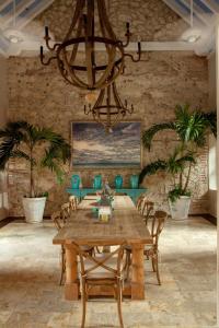 ein Esszimmer mit einem Holztisch und einem Kronleuchter in der Unterkunft Luxury 10 BR Colonial Mansion in Cartagena de Indias