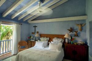 ein Schlafzimmer mit einem Bett und einem Kreuz an der Wand in der Unterkunft Luxury 10 BR Colonial Mansion in Cartagena de Indias