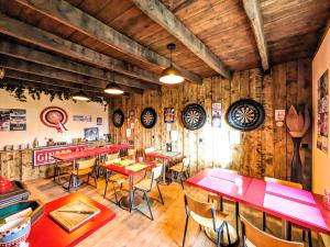 um restaurante com mesas e cadeiras numa sala com paredes de madeira em Le Noyer em Rougnat