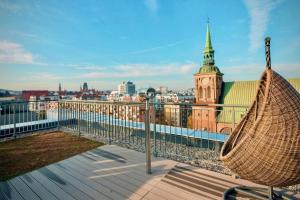 a hammock on the roof of a building with a clock tower at Długie Ogrody Garden Gates in Gdańsk