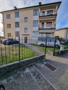 a fence in front of a building with parked cars at Bilocale Villesse 