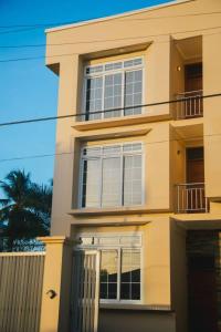 een groot gebouw met witte ramen en een palmboom bij Elegant Mine Apartment -1 in Dar es Salaam