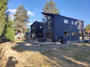 ein schwarzes Haus mit einem Picknicktisch im Hof in der Unterkunft Refugio de montaña en pleno centro Malalcahuello. in Malalcahuello