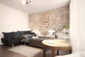 Una sala de estar con un sofá y una pared de ladrillos. en Vintage Rooms / Old Town Wroclaw / City Center, en Wroclaw