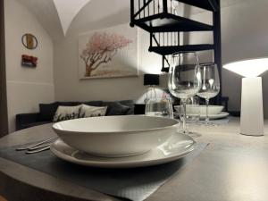 a table with a bowl and wine glasses on it at Almond apartment Catania in Catania