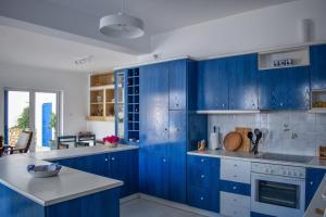 a blue kitchen with white counters and blue cabinets at Aegean Aura Apartment III in Kalymnos