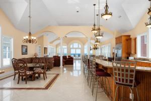 cocina y sala de estar con barra con sillas en Imperial Palace 12 Bedroom Oceanfront Home, en Kill Devil Hills