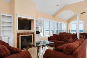 Una sala de estar con chimenea y televisión. en Imperial Palace 12 Bedroom Oceanfront Home, en Kill Devil Hills