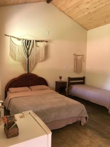 sypialnia z 2 łóżkami w pokoju w obiekcie Chalé da Mata w mieście São Roque de Minas
