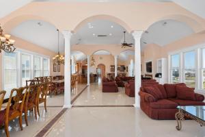 Una sala de estar con sillas y un comedor. en Royal Palace 12 Bedroom Oceanfront Home, en Kill Devil Hills