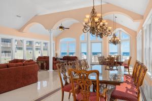 Un comedor y una sala de estar con mesa y sillas. en Royal Palace 12 Bedroom Oceanfront Home, en Kill Devil Hills