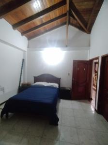 1 dormitorio con cama y techo de madera en Posada de Zory, en Santo Domingo de los Colorados