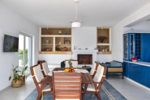 a dining room with a table and chairs and a fireplace at Aegean Aura Apartment III in Kalymnos