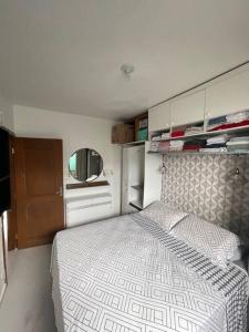 弗洛里亚诺波利斯Apartamento ingleses do rio vermelho Florianópolis的带一张大床和一面镜子的卧室