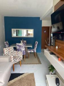 弗洛里亚诺波利斯Apartamento ingleses do rio vermelho Florianópolis的客厅设有蓝色的墙壁和桌椅