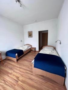 twee bedden in een kamer met houten vloeren bij Koral Świnoujście in Świnoujście