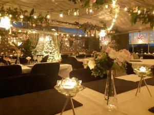 a room with white tables and flowers and lights at Närebo Gårdshotell & Restaurang in Lidköping