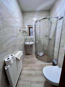 Koral Świnoujście في سفينويتشي: حمام مع دش ومرحاض ومغسلة