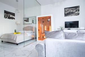 biały pokój z łóżkiem i kanapą w obiekcie Apartament Silver SAUNA&JACUZZI Poznań Stare Miasto w Poznaniu