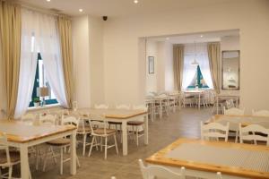 Koral Świnoujście في سفينويتشي: غرفة طعام مع طاولات وكراسي ونوافذ