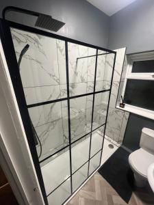 a bathroom with a glass shower with a toilet at Cosy home perfect for families and contractors with free parking in Darlington +13 photos
