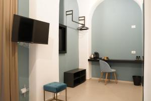 a living room with a tv and a chair at La Regina del Duomo Catania Centro in Catania