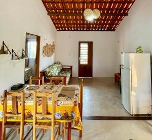 a kitchen and living room with a table and a refrigerator at Casa Ariacó in Amontada