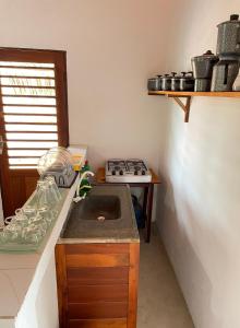 a kitchen with a sink and a stove at Casa Ariacó in Amontada