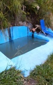 un hombre sentado en una mesa en una piscina en Cabin in the Mountains - Chalet, en Ibagué