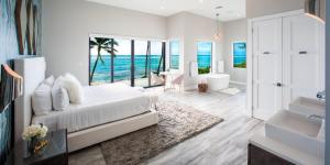 a white bedroom with a view of the ocean at Evolution villa in Bodden Town