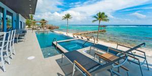 a resort with a swimming pool and the ocean at Evolution villa in Bodden Town