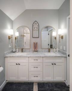 a bathroom with two sinks and a large mirror at Fawn Chalet in the Prescott Pines Near Downtown in Prescott