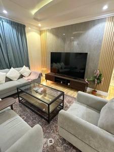 ein Wohnzimmer mit 2 Sofas und einem Flachbild-TV in der Unterkunft شقة جميلة بغرفتين نوم ودخول ذاتي 106B in Riad
