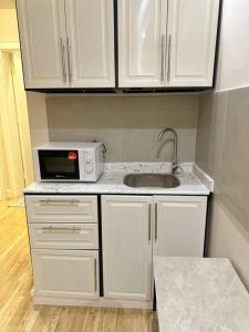 a small kitchen with a sink and a microwave at شقة جميلة بغرفتين نوم ودخول ذاتي 106B in Riyadh