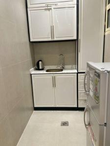 a small kitchen with a sink and white cabinets at 106A شقة جميلة بغرفتين نوم ودخول ذاتي in Riyadh