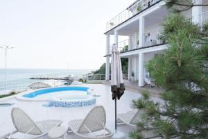 a house with a pool and chairs and an umbrella at Belaya Udacha in Odesa