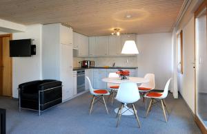 a kitchen with a table and chairs in a room at Apartment Lenkstrasse 6 C in Lenk