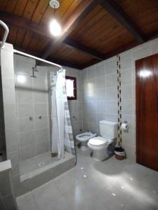 a bathroom with a toilet and a shower with a shower at Cabañas Lamani in Lago Puelo